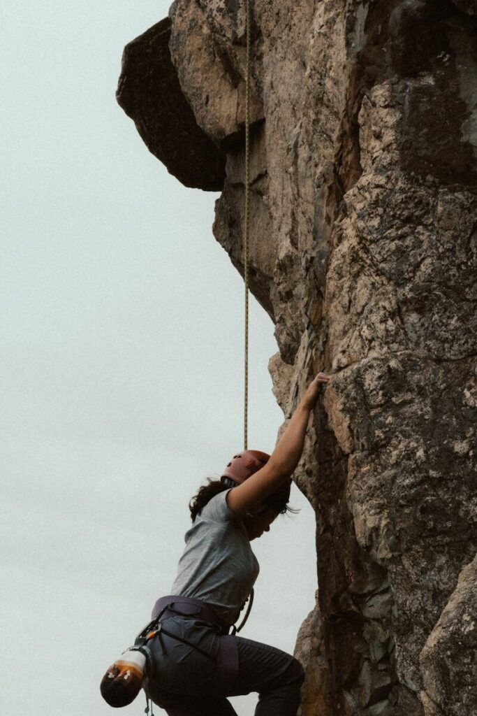 A person rock climbing a steep cliff face